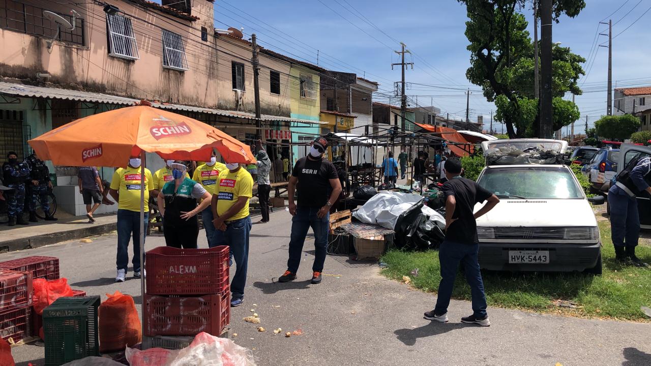 fiscais e guardar em pé em frente à barracas de feira sendo desmontadas